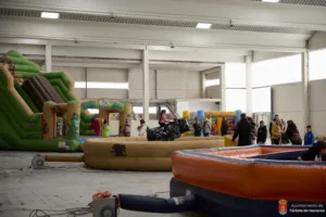 Decenas de niños saltan y juegan sin parar en la fiesta de hinchables del polideportivo municipal