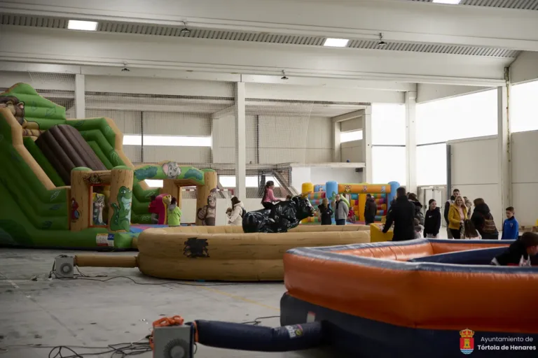 Decenas de niños saltan y juegan sin parar en la fiesta de hinchables del polideportivo municipal